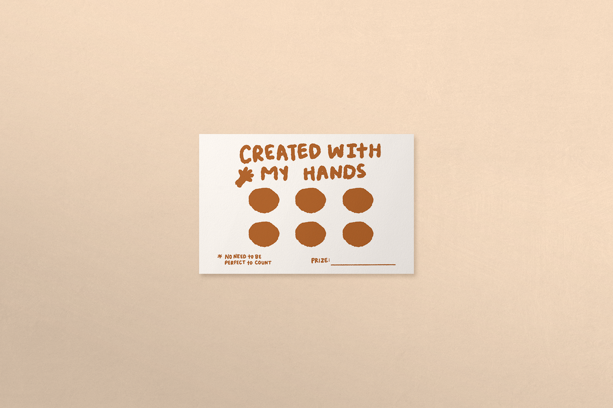 Card with 'Created with my hands' text and hand icon on a beige background